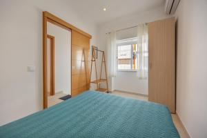 a bedroom with a blue bed and a window at Lanzarote Villa in Alvor