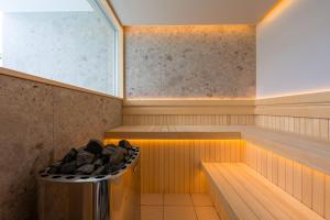a sauna with a bench with rocks in it at COCO VILLLA 沖縄今帰仁-Okinawa nakijin in Nakijin