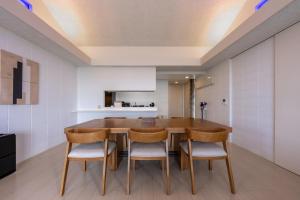 a dining room with a wooden table and chairs at COCO VILLLA 沖縄今帰仁-Okinawa nakijin in Nakijin