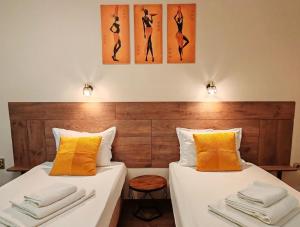 two beds in a hotel room with orange pillows at Hotel Sorbona in Varna City