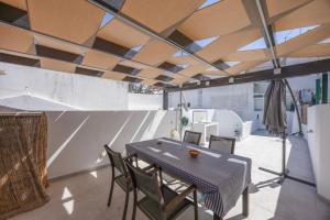 a table and chairs in a room with a ceiling at Lanzarote Villa in Alvor