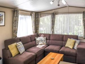 a living room with a brown couch and a table at Maggie's Place in Dunkeld