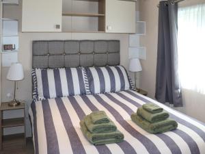 a bedroom with a bed with two towels on it at Maggie's Place in Dunkeld