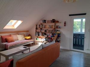 a living room with a couch and a book shelf at appartement dans maison, calme assuré in Corancy