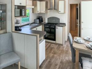 a kitchen with white cabinets and a table and a stove at Maggie's Place in Dunkeld +10 photos