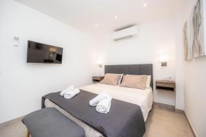 a bedroom with two beds and a flat screen tv at Apartamento Lliteras 2C Ref 9003 in Cala Millor