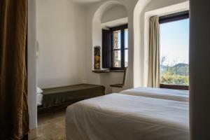 a bedroom with two beds and a window at Eremito in Parrano