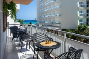 a patio with chairs and tables on a balcony with the ocean at Apartamento Lliteras 2C Ref 9003 in Cala Millor