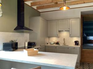 a kitchen with white cabinets and a counter top at The Studio Cottage in Knock