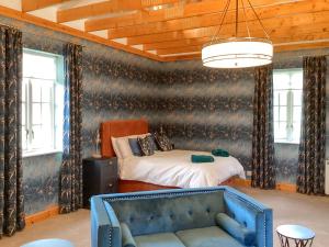 a bedroom with a bed and a couch in a room at The Studio Cottage in Knock