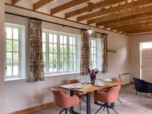 a dining room with a table and chairs and windows at The Studio Cottage in Knock