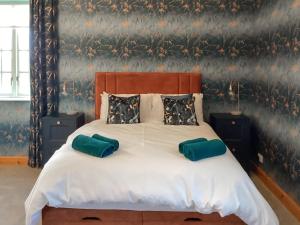 a bedroom with a large bed with two pillows at The Studio Cottage in Knock