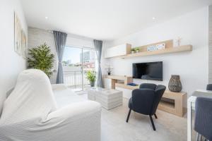 a living room with white furniture and a tv at Apartamento Lliteras 2C Ref 9003 in Cala Millor