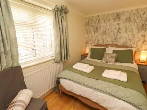 a bedroom with a large bed and a window at Rose Briar Cottage in Morpeth