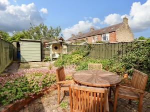 a patio with a table and chairs and a fence at Rose Briar Cottage in Morpeth