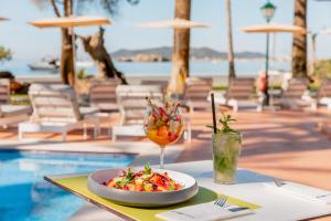 a table with a plate of food and a drink at THB Los Molinos - Adults Only in Ibiza Town