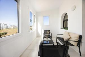 a living room with a table and chairs and a window at Finca Isla Verde in Chipiona