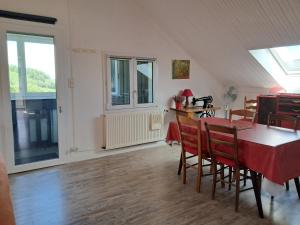 a dining room with a table and chairs and a window at appartement dans maison, calme assuré in Corancy