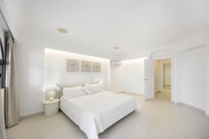 a white bedroom with a white bed and white floors at Finca Isla Verde in Chipiona
