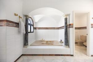 a bathroom with a tub and a toilet at Finca Isla Verde in Chipiona +122 photos