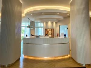 a lobby with a white counter in a building at Residence Hotel Piccadilly in Rimini