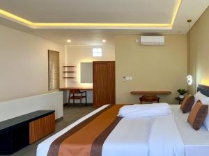 a bedroom with a large bed and a desk at Mimpi Ayung Villas by AGATA in Bringkit
