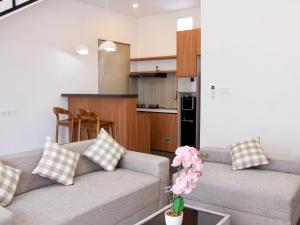 a living room with two couches and a kitchen at Mimpi Ayung Villas by AGATA in Bringkit