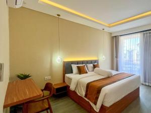 a bedroom with a bed and a table and a desk at Mimpi Ayung Villas by AGATA in Bringkit