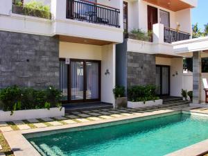 a villa with a swimming pool in front of a house at Mimpi Ayung Villas by AGATA in Bringkit