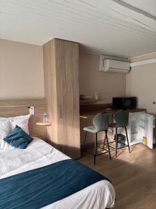 a hotel room with a bed and a desk and a kitchen at Oyonnax Bellignat Appart Hotel in Bellignat