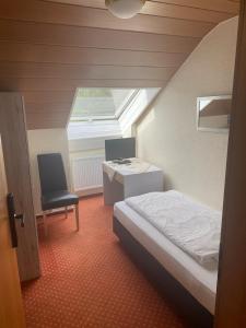 ein Schlafzimmer mit einem Bett, einem Schreibtisch und einem Stuhl in der Unterkunft Hotel-Windeck in Burbach