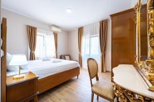 a hotel room with a bed and a desk and a chair at Hotel Perun in Budva