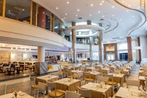 a dining hall with tables and chairs in a restaurant at SRNTY Sea Reef - Ex Serenity Alpha Beach in Hurghada
