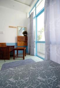 a room with a bed and a table and a window at OHA Homestay in Quy Nhon