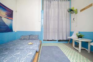 a bedroom with a bed and a table and a window at OHA Homestay in Quy Nhon