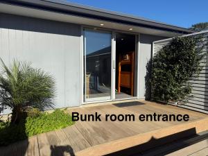 a house with a front porch with a bump room entrance at Pineapple Palace Studio in Raglan +1 photo