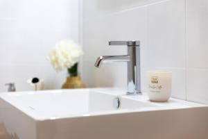 a sink with a faucet and a cup on it at Appartamenti Da Ewa Valledoria in Valledoria +31 photos