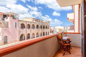 a balcony with a table and a view of a building at Appartamenti Da Ewa Valledoria in Valledoria