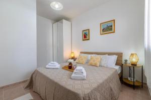 a bedroom with a bed with towels on it at Appartamenti Da Ewa Valledoria in Valledoria