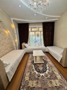 a living room with two beds and a table at Uya Nest Osh in Osh