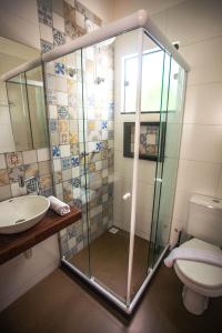 uma casa de banho com um chuveiro, um WC e um lavatório. em Guest House Cabo Frio em Cabo Frio