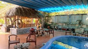 a patio with a pool and a table and chairs at Cactos Pool & Palms Local Stay in Ho Chi Minh City