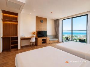 a hotel room with two beds and a television at Maris Apec Tuy Hoà in Tuy Hoa