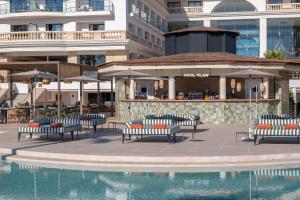 a pool with chairs and umbrellas next to a building at Sarena de Muro Resort Mallorca, part of Destination by Hyatt in Playa de Muro