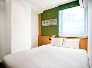 a bedroom with a white bed and a window at SONO Moon Nagoya in Nagoya