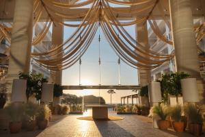 a large building with a ceiling with curtains and potted plants at Sarena de Muro Resort Mallorca, part of Destination by Hyatt in Playa de Muro