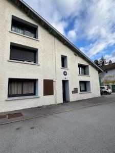 a white brick building with windows on a street at Oyonnax Bellignat Appart Hotel in Bellignat