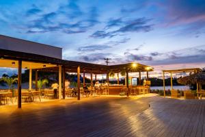 a deck with tables and chairs at night at Pacas Suítes Lençóis Eco Lodge in Santo Amaro