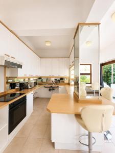 a kitchen with white cabinets and a wooden counter top at 12 On Braemar Guesthouse in Cape Town