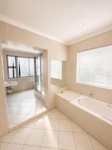 a large bathroom with a tub and a sink at 12 On Braemar Guesthouse in Cape Town +13 photos